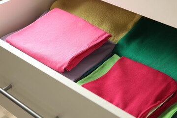 Poster - Chest of drawers with different folded clothes, closeup