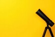 © Kanyakarn - A telescope positioned against a bright yellow background, ideal for astronomy enthusiasts and educational themes.