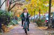 © Volodymyr - Happy kid boy riding a bike in the autumn park. Little kid boy in warm clothes in autumn park driving a bicycle. Active child cycling on sunny fall day in nature. Autumn leisure with kids.