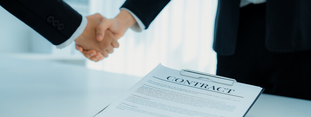 Wall Mural - Two business executive shake hand in boardroom, sealing agreement merging two company. Handshake symbolize business partnership and cooperation. Corporate acquisition and merger concept. Shrewd