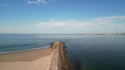 Sticker - Aerial view of Atlantic Ocean with empty sandy beach and stone breakwater on a sunny day