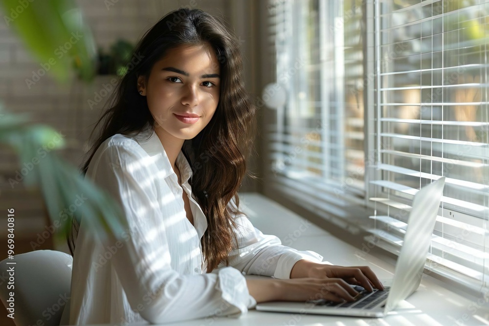 young Latina woman sitting at her home office desk, collaborating with ...