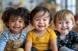 © Yuliia - Three toddler kids from diverse backgrounds sitting together and smiling joyfully, showcasing the beauty of multicultural inclusion and diversity.