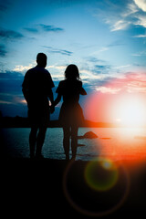 Wall Mural - happy couple by the sea on nature silhouette background