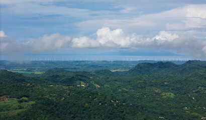 Many windmills next tol lake on green mountain landscape  aerial drone view