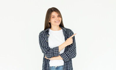 Hey look. Smiling pretty female model pointing fingers right at empty space and inviting to check it out, showing advertisement on white background.