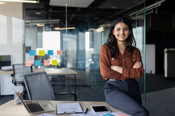 portrait of young beautiful latin american business woman, company employee smiling and looking at c