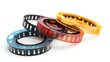 © sablengjago - Three film reels, one black, one brown, and one yellow, on a white background.