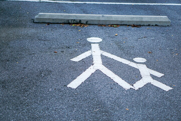 The white painted parent and child symbol on the parking lot represents the family's parking lot.