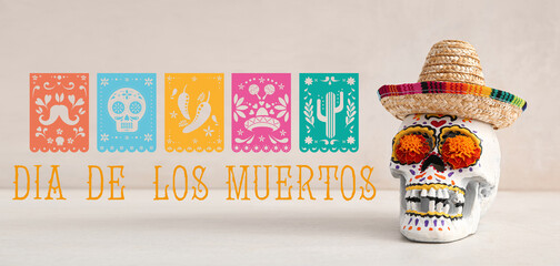 Wall Mural - Painted skull with marigold flowers and sombrero on white table. Celebration of Mexico's Day of the Dead (El Dia de Muertos)