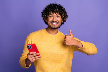 Sticker - Photo of funny cheerful handsome man user wear trendy yellow clothes hold gadget thumb up isolated on violet color background