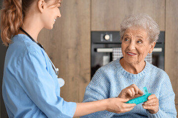 Poster - Senior woman with doctor taking pills in kitchen