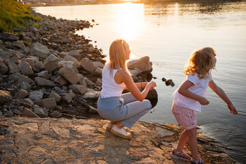 summer evening by the drava river in osijek, croatia with children playing near the water