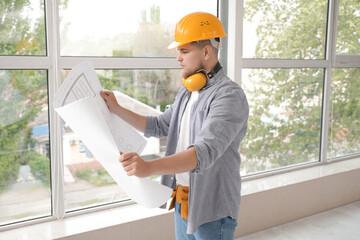 Poster - Male contractor with house plan near window in room