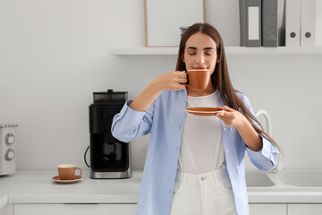 Canvas Print - Beautiful young happy woman with cup of coffee having break at kitchen in office