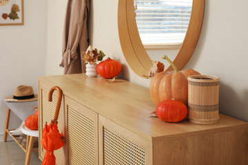 Wall Mural - Mirror, chest of drawers, hanging coat, pumpkins with autumn leaves and umbrella in interior of hallway