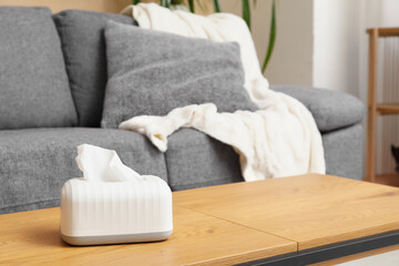 Tissue in ceramic holder on coffee table in living room. Closeup