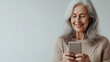 © Julia Zarubina - beautiful smiling elderly gray-haired woman holding smartphone, granny talking on mobile phone, old lady, white background, pensioner, retired person, elderly lifestyle, female portrait, communication