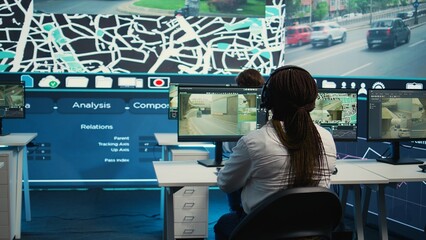 Cargo shipping agency employees operating on city satellite map to communicate the best routes for the colleagues on the field. Operators monitoring their cars and couriers in traffic. Camera B.