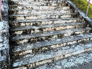 Weathered concrete stairs with metal handrail outdoors