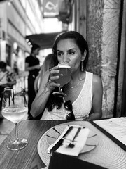 Attractive Hispanic Woman drinking a beer at an outdoor table in Spain