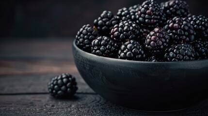 Poster - Ripe blackberries in a dark bowl on a wooden table