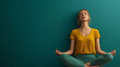 © iamfrk7 - Woman practicing yoga meditation in yellow top against teal background, emphasizing mindfulness, balance, and mental well-being, in a serene and focused pose