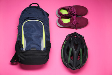 Poster - Backpack, bicycle helmet and sneakers on pink background, flat lay