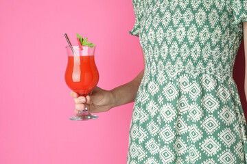 Wall Mural - Woman with glass of refreshing cocktail on pink background, closeup