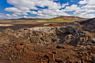 Amazing lava field in the highlands of Iceland near Myvatn, black old lava flows and volcanic rocks, mountains in the background