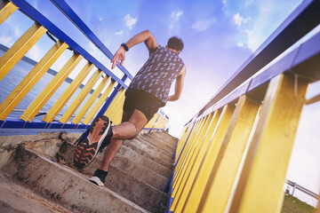 Wall Mural - Young man running sprinting up stairs at stadium with speed zoom blur effect. Fit runner fitness runner during outdoor workout. Selected focus