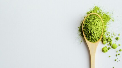 A bamboo spoon filled with bright green matcha powder resting on a white background, highlighting its earthy tones