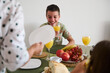 © Taras Grebinets - Joyful family breakfast with happy young boy enjoying fresh juice and fruit at the dining table