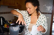 © Taras Grebinets - Woman preparing coffee in a modern kitchen, enjoying a morning routine with freshly brewed beverage and wearing casual attire