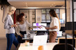 © Wavebreak Media - Discussing project ideas, three multiracial women collaborating in modern office with laptops