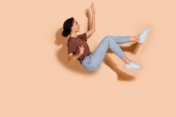 Canvas Print - Photo of lovely cheerful woman wear brown stylish clothes fly levitate air empty space isolated on beige color background