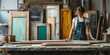 © syhin_stas - A carpenter designer stands in her workshop, examining wooden planks on a workbench and choosing the right one for her next project.