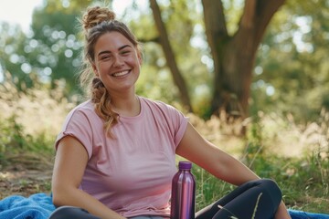 Wall Mural - A woman smiles while sitting outdoors with a water bottle. AI.