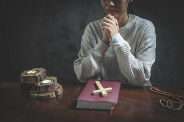 woman praying on holy bible in the morning. woman hand with Bible praying. Hands folded in prayer on a Holy Bible in church concept for faith, spirituality and religion.