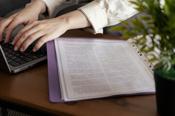 Woman typing on laptop close-up and working remotely at home with focus. Working with documents