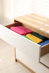 Sticker - Chest of drawers with different folded clothes, closeup