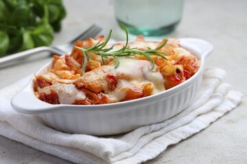 Delicious al forno pasta in baking dish on light table, closeup