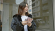 © Krakenimages.com - A young hispanic woman counts colombian pesos on a busy urban street.