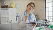 © Krakenimages.com - Young caucasian female doctor in glasses holding clipboard and pen in a laboratory indoor setting.