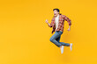 © ViDi Studio - Full body sideways profile young happy man he wearing red checkered shirt casual clothes jump high run fast hurry up, be in rush isolated on plain yellow orange background studio. Lifestyle concept.