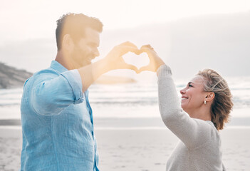 Sticker - Beach, happy couple and heart hands for love, support and care on holiday outdoor. Romance, man and woman with sign at ocean for healthy relationship, connection and commitment in summer with flare