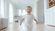 © Business Image - Joyful young boy running indoors in a bright modern home