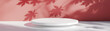 © MVM - White empty round podium with soft maple leaf shadows on a warm red background. Product display background with copy space