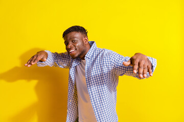 Photo of young handsome american model guy wearing casual plaid shirt invites to private party isolated on yellow color background