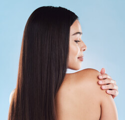 Beauty, hair and back of woman in studio for salon, wellness and keratin treatment for texture. Hairdresser, spa aesthetic and isolated person with shine, cosmetics and health on blue background